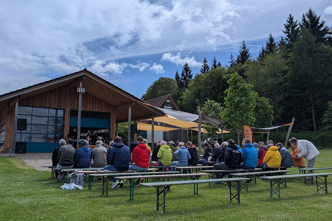 Himmelfahrts-Gottesdient auf dem CVJM-Plätzle in Renningen Himmelfahrtsgottesdienst auf dem CVJM-Plätzle in Renningen. Die Besucherinnen und Besucher sitzen auf Bierbänken im Freien und folgen dem Gottesdienst mit Band.